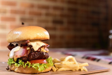 beef burger with sandwich bun salad onion and cheese fast food isolated on wooden table
