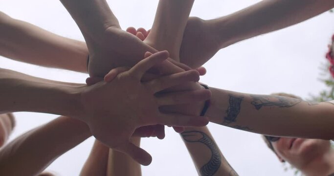 Team members come together by holding hands working closely together to achieve common goal. This fosters strong sense of teamwork, camaraderie, shared commitment to success. People lifestyle