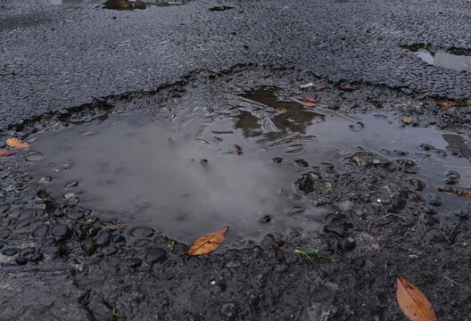 water fills the holes in the asphalt