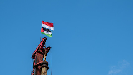 the Indonesian flag and the flag of the state of Palestine are flying on a pole