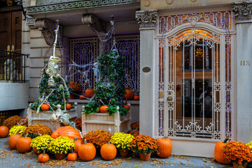 Colorful Pumpkins and Flowers on the Stairs of an Old Brownstone Home in New York City during...