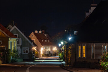 Fototapeta premium Bastad, Sweden Small cottages at night on the landmark and picturesque Agardhsgatan and street lamps. .