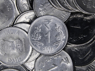 closeup top view shot of indian 1 or one rupee shiny silver coins in a messy mixed up pile 