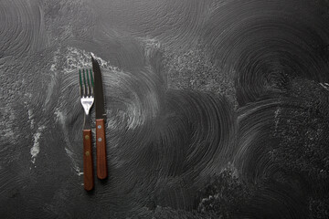 Fork and knife on a gray texture background
