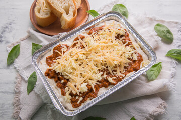 Bolognese and pesto frozen Lasagna on metal Tray for food delivery