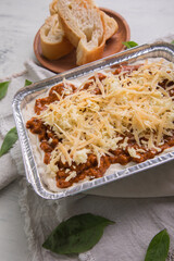 Bolognese and pesto frozen Lasagna on metal Tray for food delivery