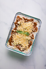 Bolognese and pesto frozen Lasagna on metal Tray for food delivery