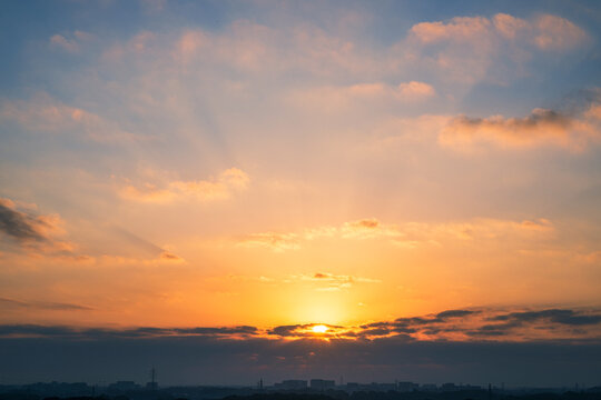 日の出の太陽と朝焼けの高積雲