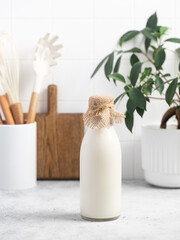 Milk in a glass, bottle of milk, light stylish kitchen