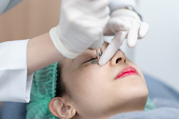Woman receiving pico laser facial treatment under eye in beauty Clinic.