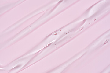 Liquid gel smear isolated on pink background. Beauty cosmetic smudge such as pure transparent aloe...