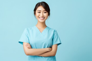A pleased nurse in scrubs, with a stethoscope around the neck, smiling compassionately, isolated on a solid background.