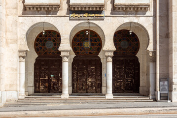 Architectural detail of the famous Abdullah Ibn Salam Mosque, which was formerly a Synagogue. Oran, Algeria.Archs, columns, wooden carved giant doors. Translation in English : mosque Salam.