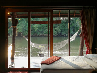Relax beside the river on the cradle. Small resort along the river. Holiday and travel at Kanchanaburi, Thailand.
