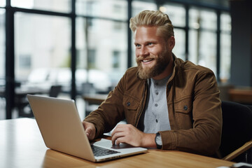 Man sitting in front of laptop computer. Suitable for technology, remote work, or online learning concepts.