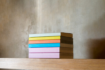 Stack of colorful books on floating wooden bookshelf. Education and knowledge concept. Pile of...