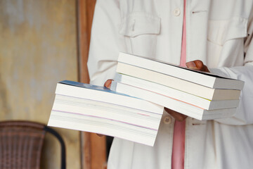 Male hand holding a stack of books. Education and knowledge concept. Portrait of young man book...