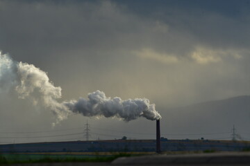 industrial chimney on a plant in nice sunlight with big clouds