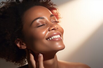 Close-up of young smiling African American woman with her eyes closed. Beautiful face of colored girl with perfect skin. Skin care, facial cosmetics. Monochrome background, copy space.