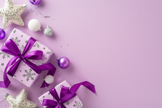Celebrate with this present-themed image concept. Overhead shot of stunning lilac gift boxes, celebratory baubles, glistening stars, sequins against purple background, perfect for personalized message