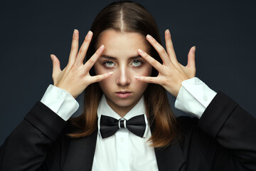 Teen Girl hiding Face with Hands Open Fingers. Young Woman Magician hypnotize. Illusionist in white...
