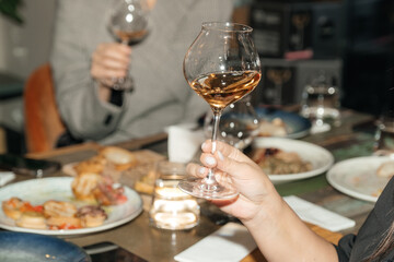 Female hands close-up with a glass of wine. Wine degustation.