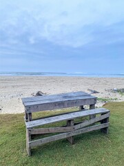 Bench table on grass next to beach