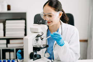 Female scientist researcher conducting an experiment working in chemical laboratory.