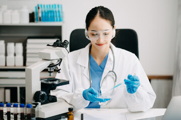 Female scientist researcher conducting an experiment working in chemical laboratory.