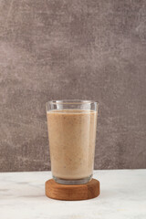 Date milk in tall glass, close-up. Milkshake with dates or palm fruits. Delicious iced cocktail. Susu Kurma, Energy protein smoothie. Healthy drink