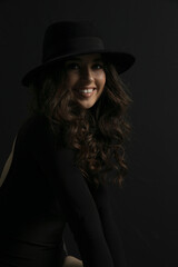 Portrait of an attractive female model in black, solated on a black background.