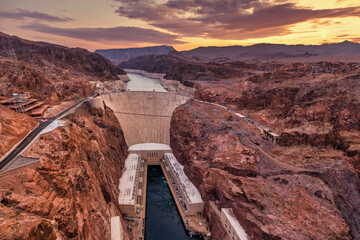 Hoover Dam on the Colorado River straddling Nevada and Arizona at dawn from above.