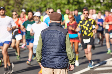 Obraz premium Old man and runners on the street. Marathon. Physical activity