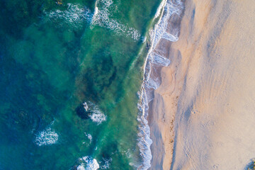 Naklejka premium zenithal aerial drone view of the shore of a beach at sunrise in the north of Portugal.