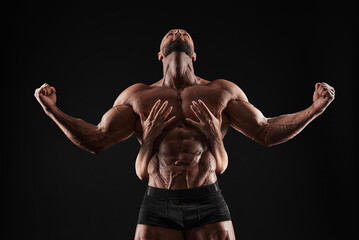 Perfect abdomen. Female hands embracing, touching muscular man abs isolated over black background. Sports, workout, bodybuilding concept.