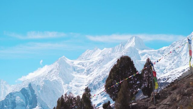 4K Time Lapse shot of clouds above the snow covered Himalayan mountain peak during the winter season at Keylong in Lahaul Valley, Himachal Pradesh, India. Clouds moving above snowy mountain peaks.