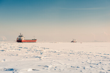 Winter shipping. Big cargo ships in frozen sea fairway