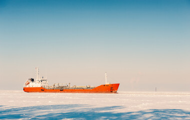 Winter shipping. Big cargo ship in frozen sea fairway