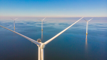 Windmill turbines at sea seen from a drone aerial view from above at a huge windmill park in the...