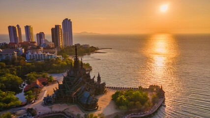 Sanctuary of Truth, Pattaya, Thailand, wooden temple by the ocean during sunset on the beach of...