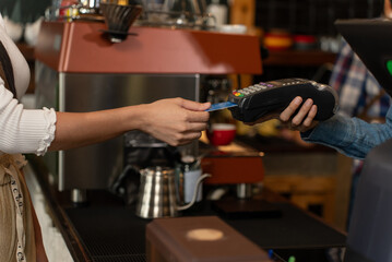 Contactless payment, Unrecognizable woman pay for coffee by credit card at coffee shop. Small business, Business owner.