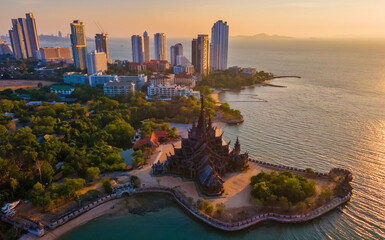 Sanctuary of Truth, Pattaya, Thailand, wooden temple by the ocean during sunset on the beach of...
