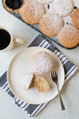 Almond muffins, fluffy and gluten free on a plate and in a muffin tin on light background. Top view