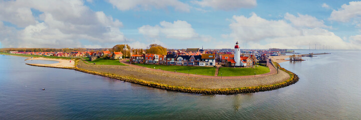 Lighthouse of Urk Netherlands, an Old historical harbor on a sunny day, a Small town of Urk village with beautiful colorful streets and houses alongside the lake Ijsselmeer Netherlands Flevoland - obrazy, fototapety, plakaty