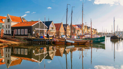 Urk Netherlands, an Old historical harbor on a sunny day, a Small town of Urk village with beautiful colorful streets and houses alongside the harbor by the lake Ijsselmeer Netherlands Flevoland - obrazy, fototapety, plakaty