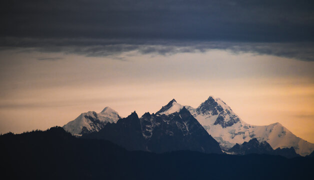 Mount kangchenjunga peak of Himalayan mountains at dawn. Snow clad white peaks under cloud cover as seen fro kalimpong india.