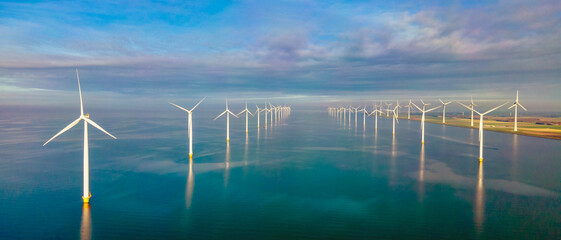 Windmill turbines at sea seen from a drone aerial view from above at a huge windmill park in the Netherlands at the Noordoostpolder in Flevoland
