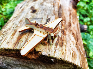 Vintage toy wooden airplane in nature. Private adventure traveling by flight. Aircraft for nature protection, eco friendly, fire extinguishing, rescue of victims. Plane crash, breakdown