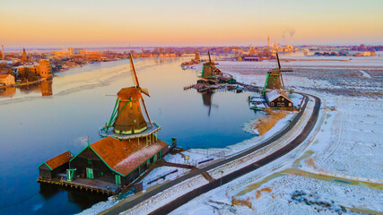 Zaanse Schans Netherlands a Dutch windmill village during sunrise at winter with a snowy landscape, winter snow at the historical windmill village near Amsterdam © Fokke Baarssen