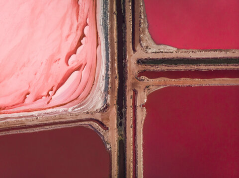Aerial view of the pink salt lake Hutt Lagoon with a dirt road separating the different colours into four squares of red and pink , Port Gregory, Western Australia.